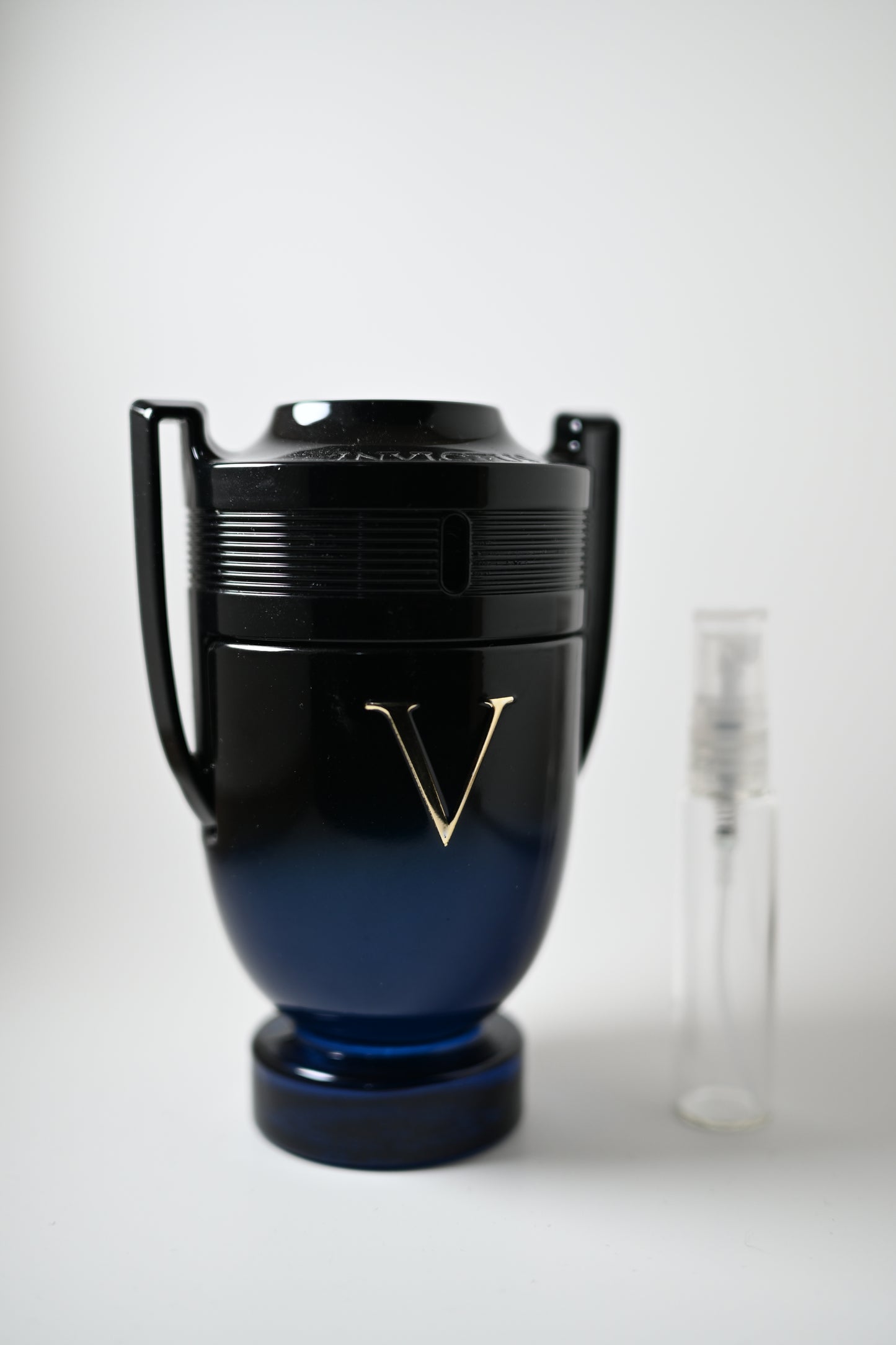 Invictus Victory Elixir Bottle Next to 10ML Decant - Perfumes de Adrian